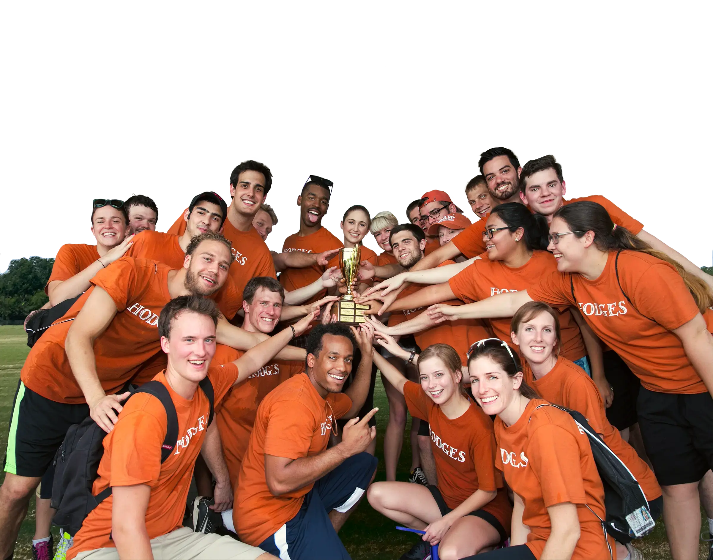 On a soccer field, law students, all wearing burnt orange t-shirts, pose in a huddle around a gold trophy