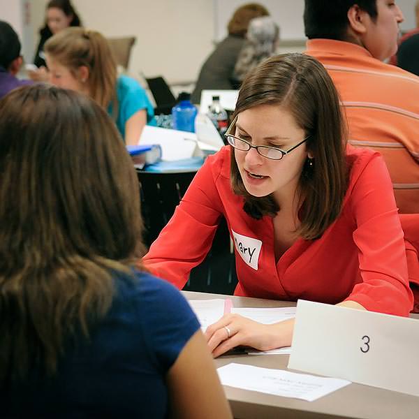Students meet over case work in a busy room