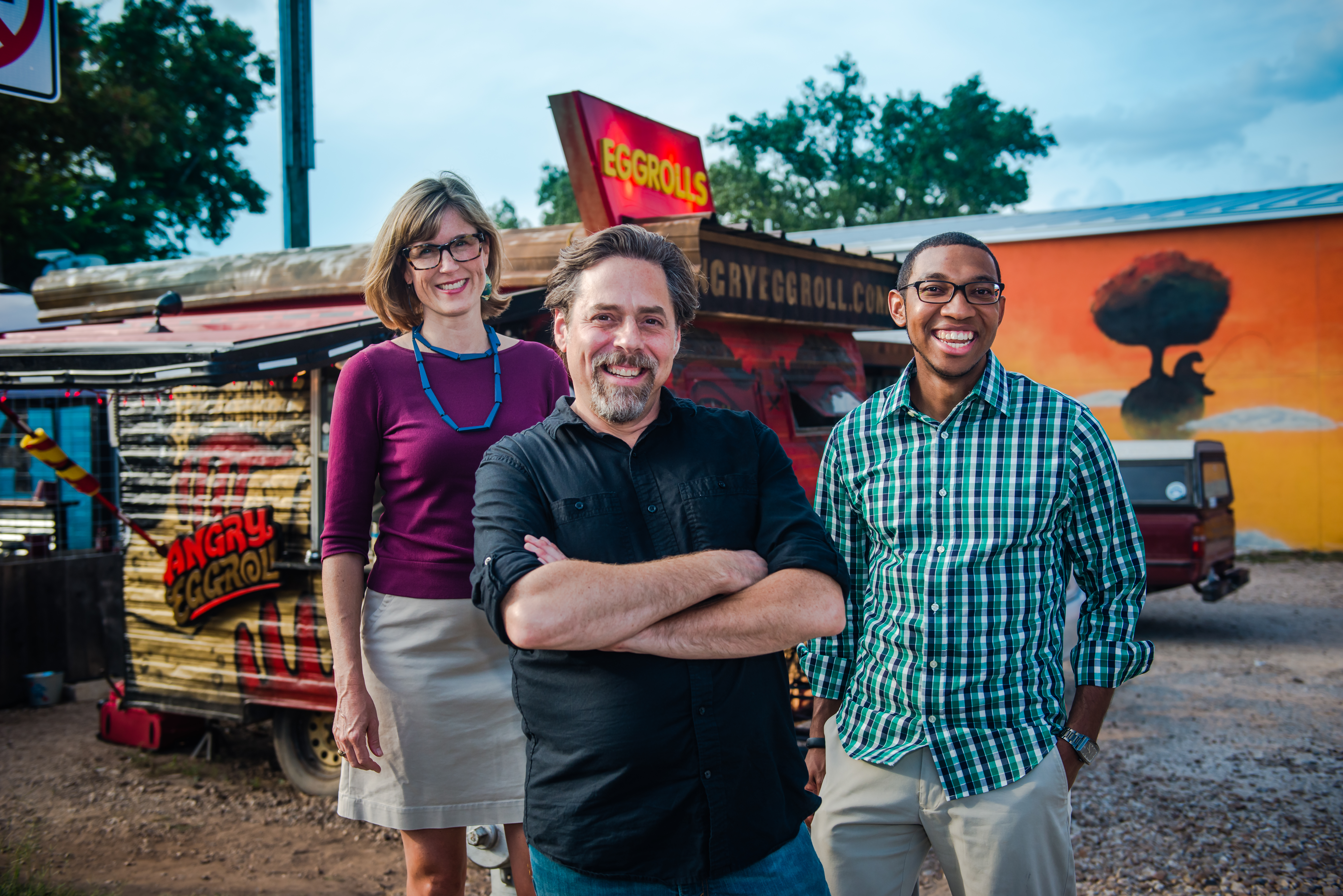 Student, faculty, and client stand in front of food truck