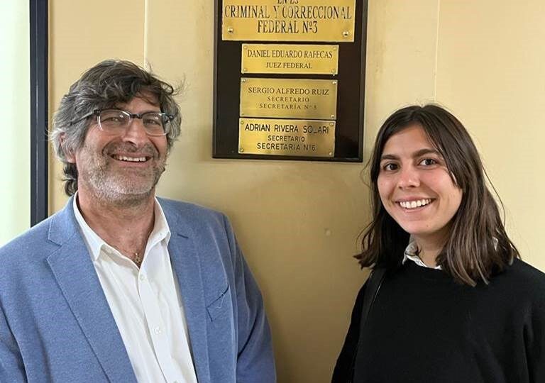 Clinical professor and student pose in front of court in Argentina.