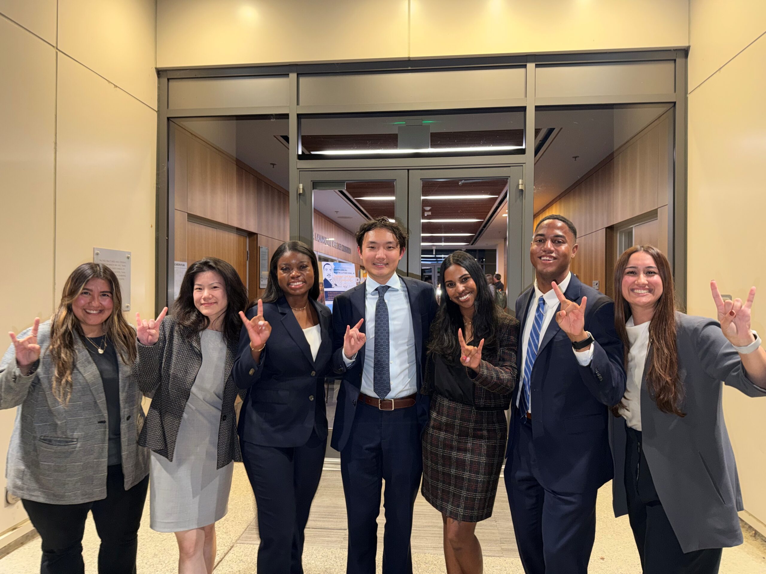 Texas Law students and coaches hold up the "Hook 'em Horns" hand sign in the courthouse in Sacramento, California.