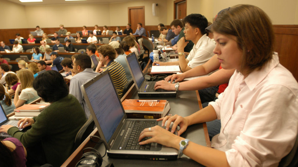 Students on laptops attentive to a class lecture