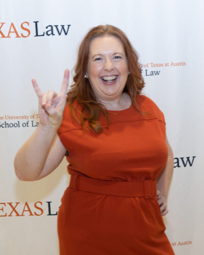 Photo of Dean Bangs holding her hand in the University of Texas "Hook 'em Horns" gesture