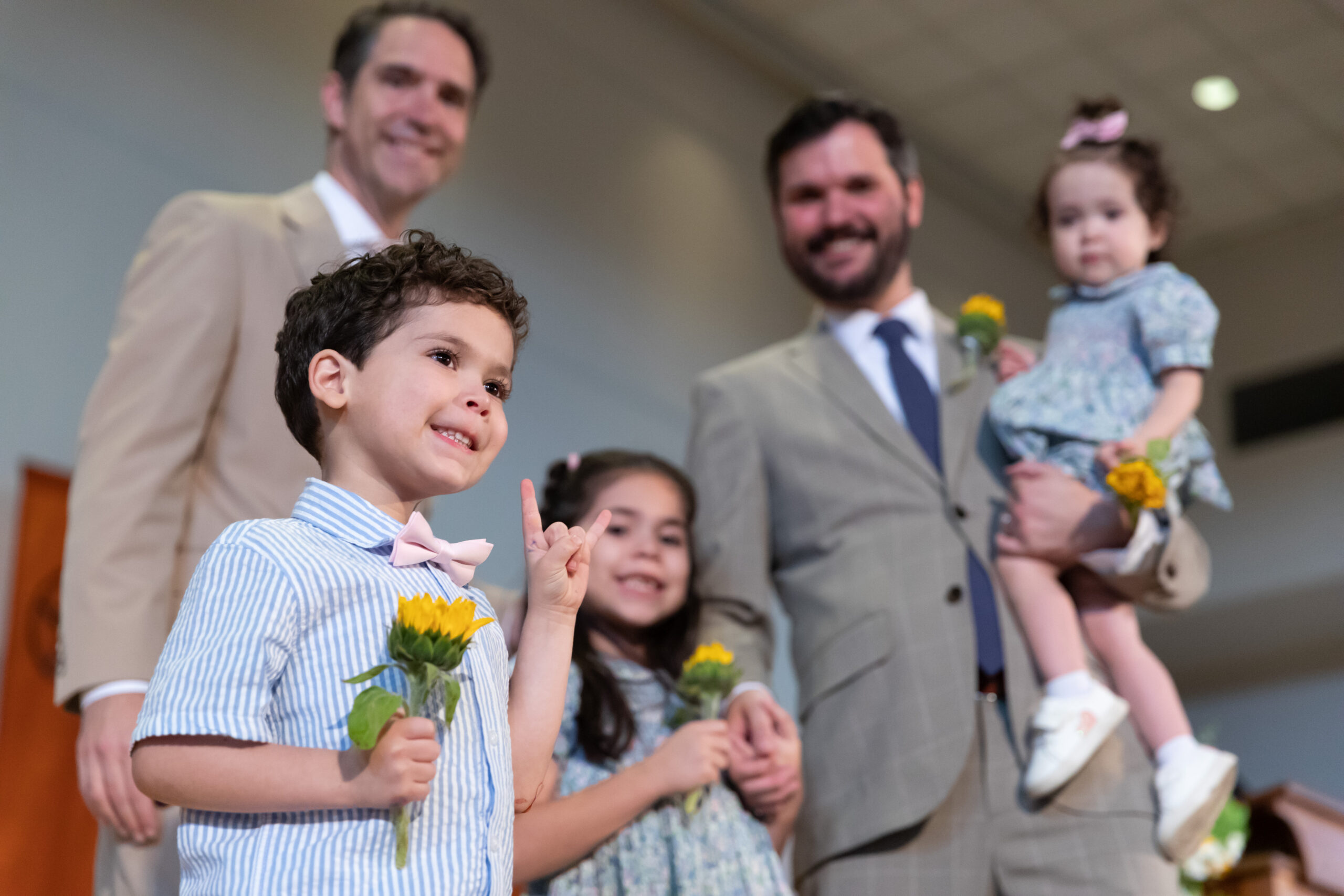 Dean Chesney in a tan suit with a Class of 2023 graduate in a light gray suit and his three children at the 2023 Sunflower Ceremony.
