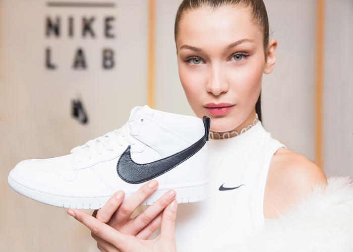 woman holds Nike shoe