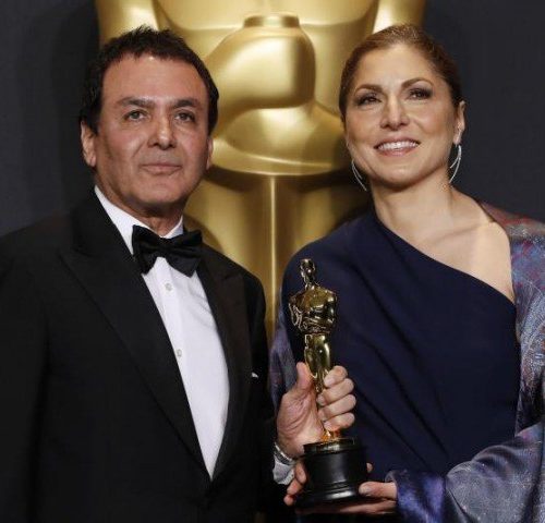 man and woman holding Oscar award