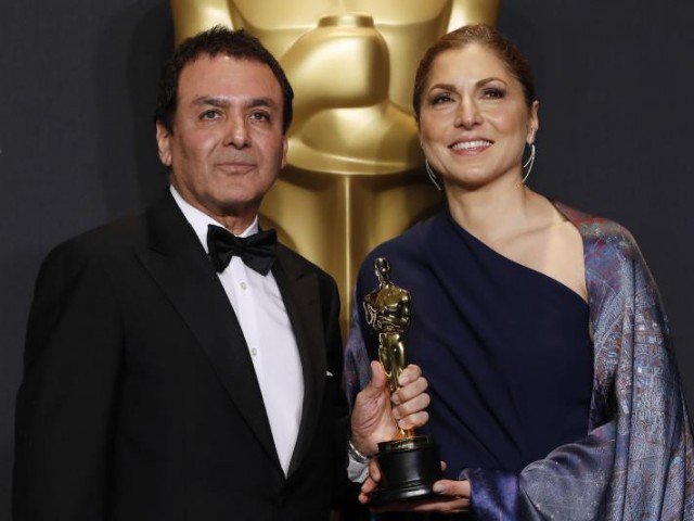 man and woman holding Oscar award