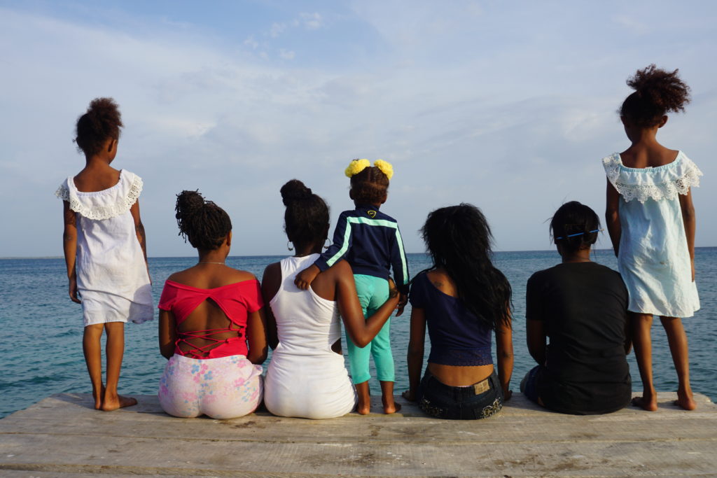 Family sits at edge of ocean