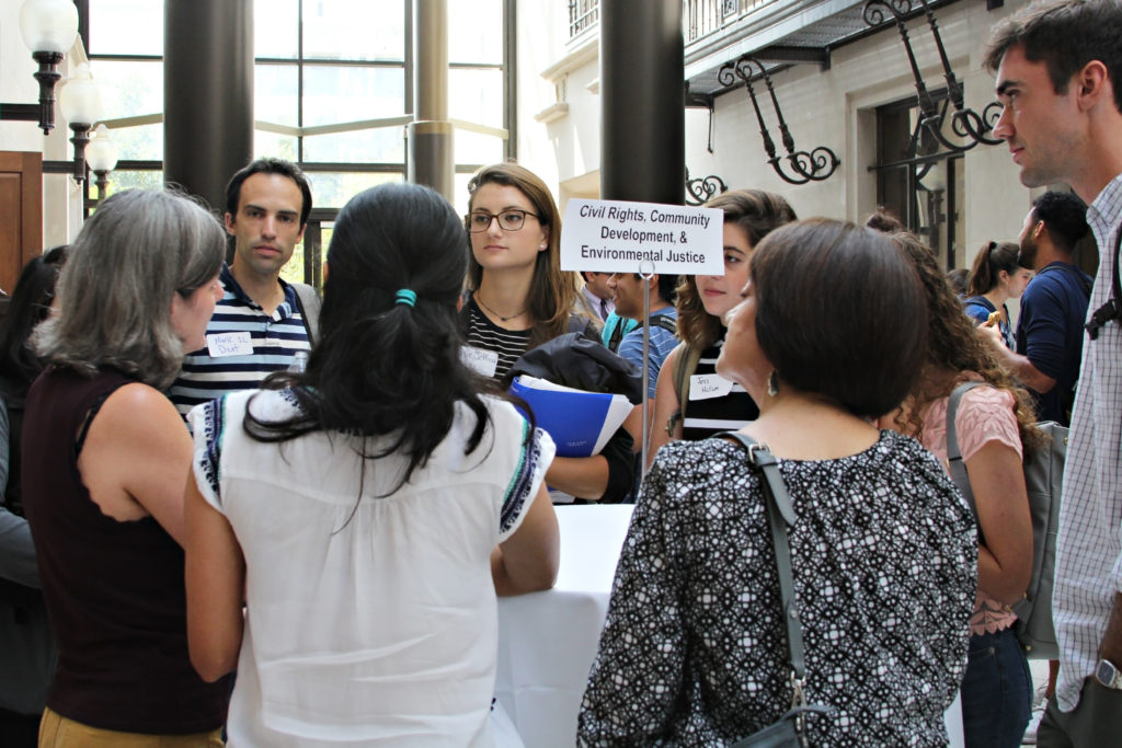 faculty and students talking at a table