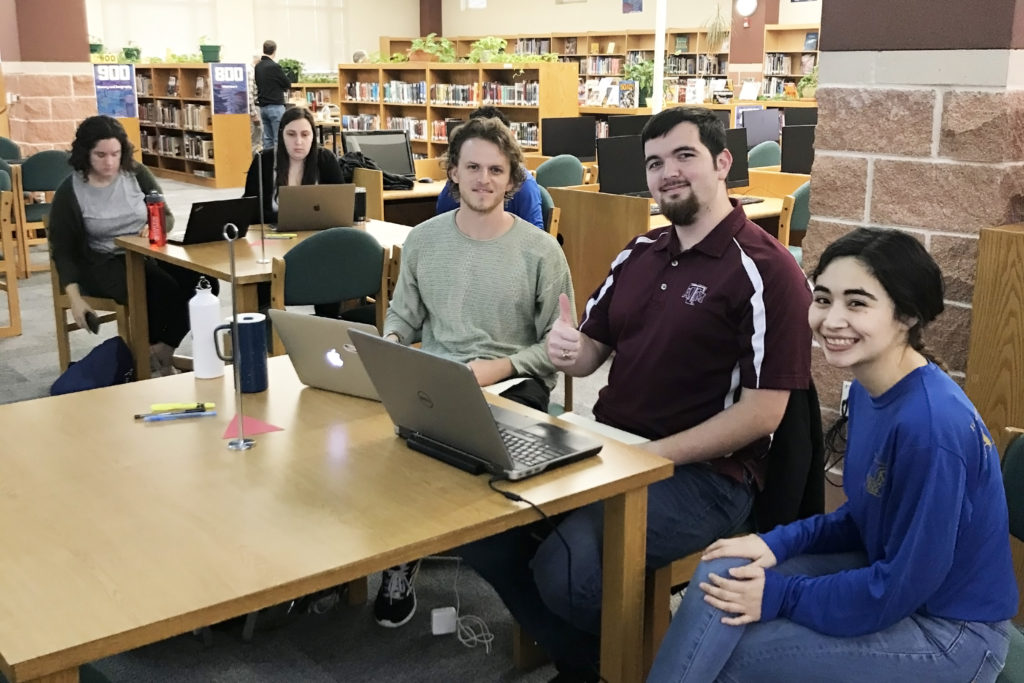 students sitting at table with computers