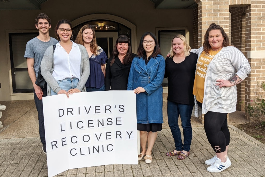 students and staff posing with sign