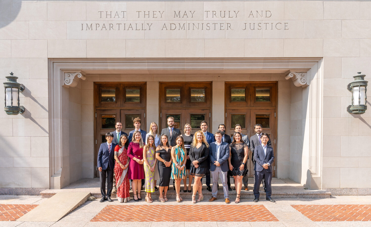 group of people standing in front of triple doors in front of Townes Hall