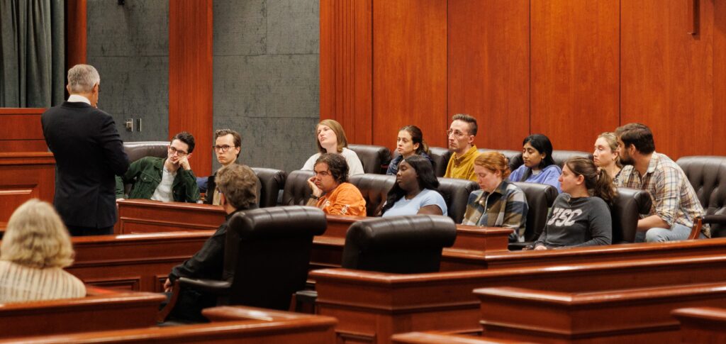 Law students at Texas Law listen while Philadelphia DA Larry Krasner speaks.