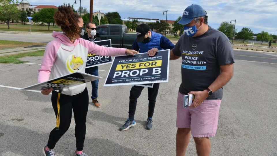 Volunteers with signs advocating for Prop B.