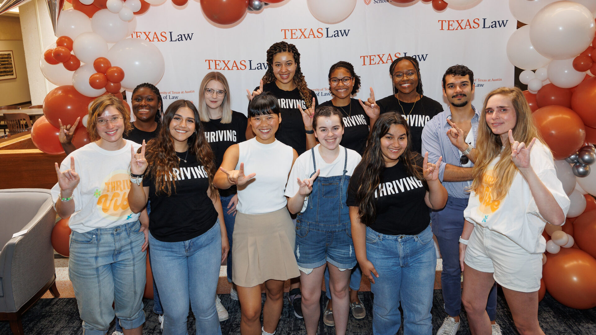 Group of students in front of Texas Law banner