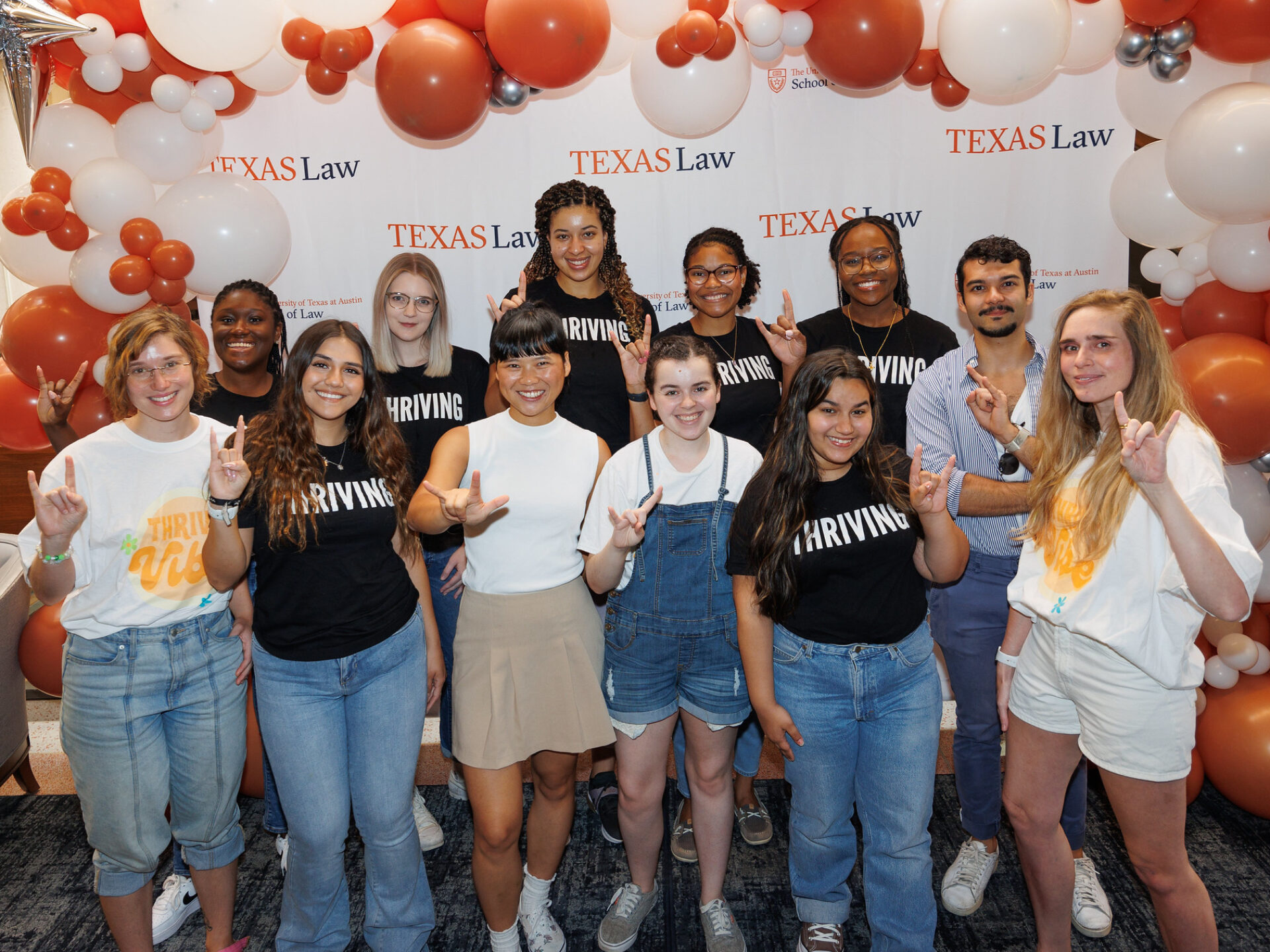 Group of students in front of Texas Law banner