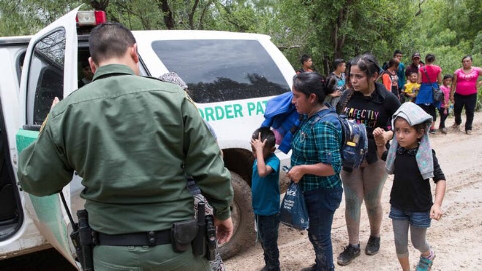 Border Patrol agents take a group of migrant families to a safer place to be transported after intercepting them near McAllen, Texas