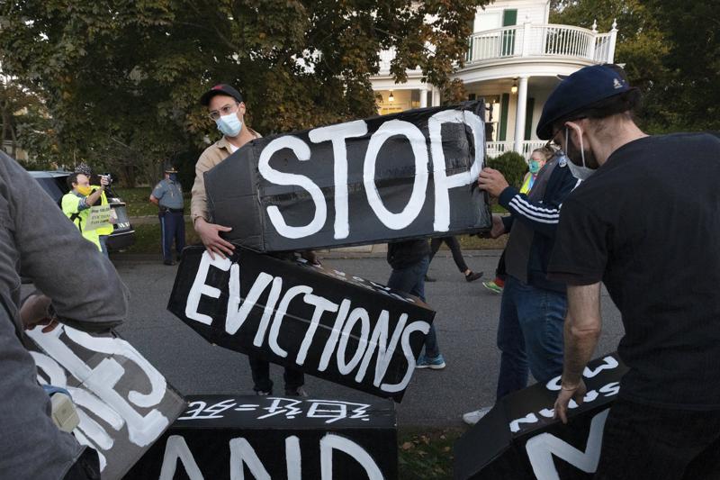 People protesting evictions, holding signs that say "stop evictions"