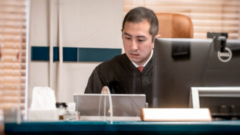 A judge looks over an iPad and digital display