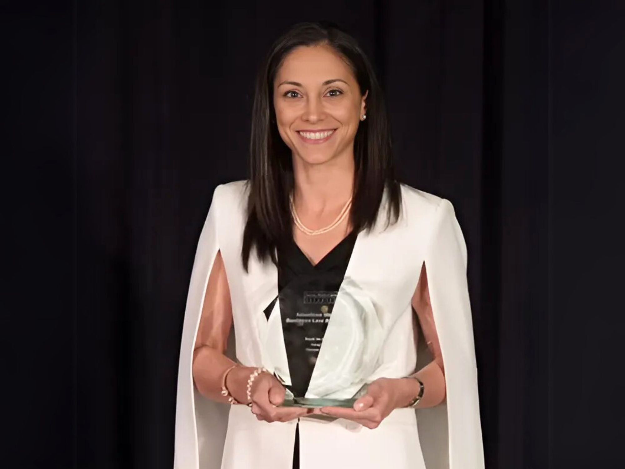 Alina Nassar holding an award.