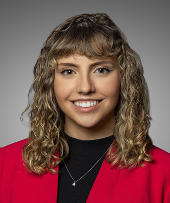 Head shot of Tori Bianco wearing red blazer, black shirt, and gold necklace.