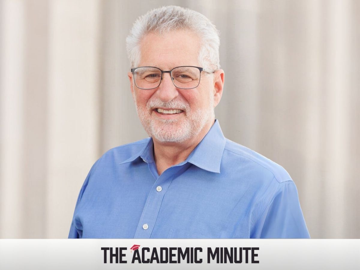 Prof. Charles Silver, a white man with glasses, silver hair, and a short, silver beard, wears a blue button-down shirt with the collar open.