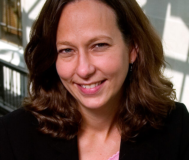Portrait of Denise Gilman, wearing a pink blouse and a black blazer.