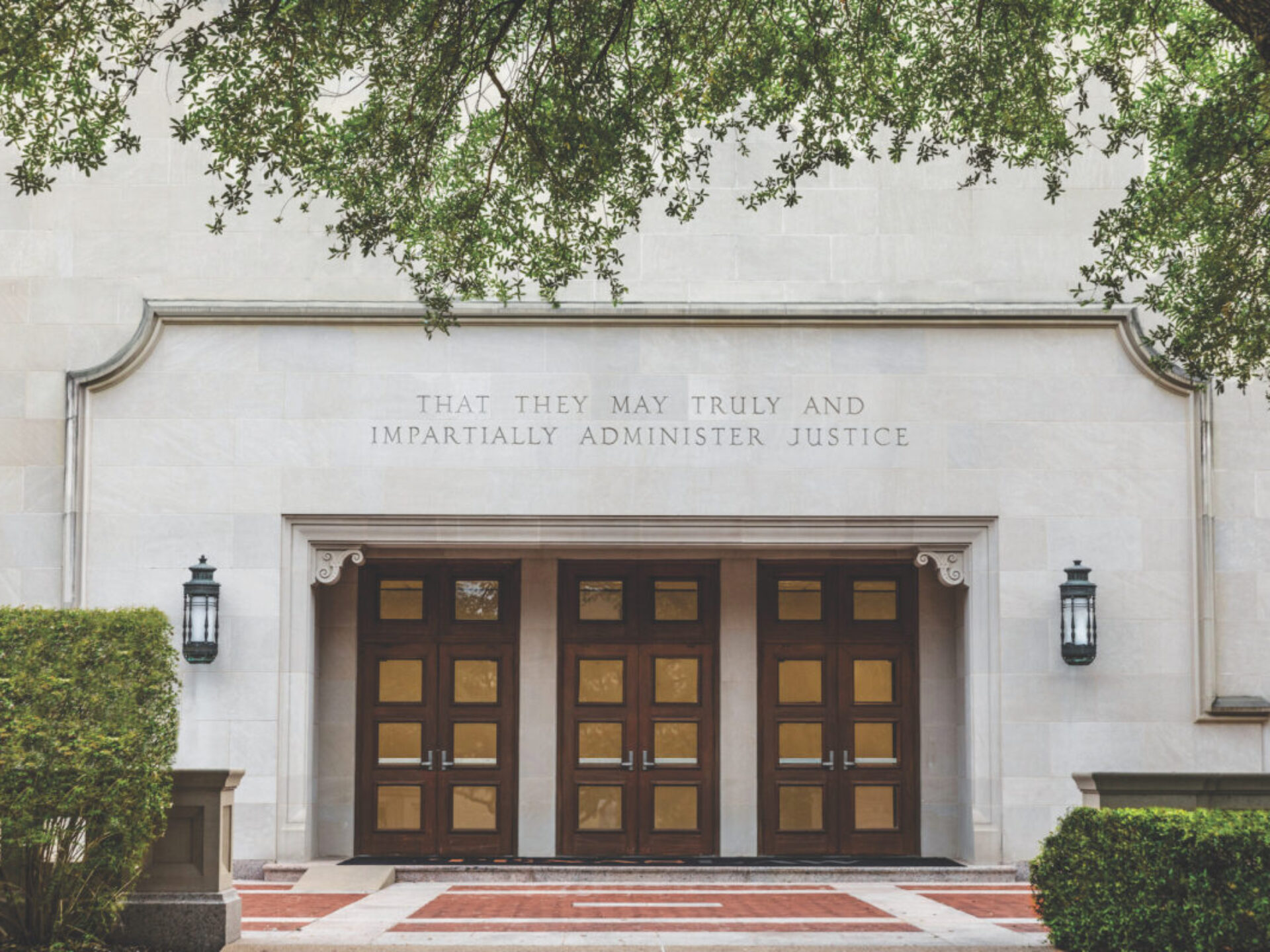The exterior doors of Townes Hall at the University of Texas School of Law, with an inscription chiseled above: "That they may truly and impartially administer justice."