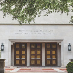 The exterior doors of Townes Hall at the University of Texas School of Law, with an inscription chiseled above: "That they may truly and impartially administer justice."