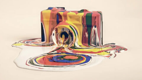 An artistic graphic of a camera covered in watercolor paints.