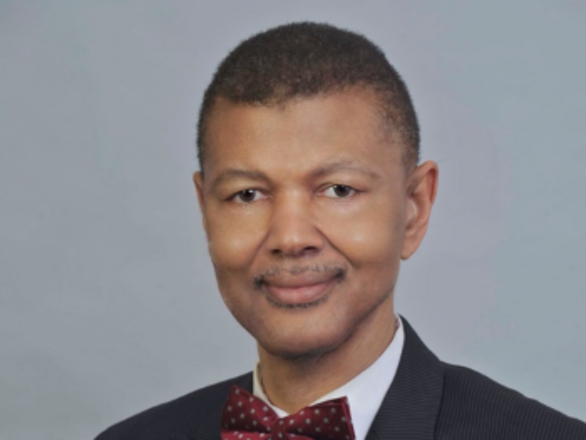 Portrait of Gary Bledsoe, wearing a black jacket and a red bow tie with white polka dots.