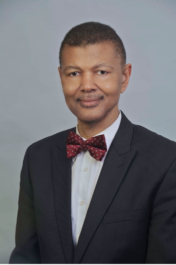 Portrait of Gary Bledsoe, wearing a black jacket and a red bow tie with white polka dots.