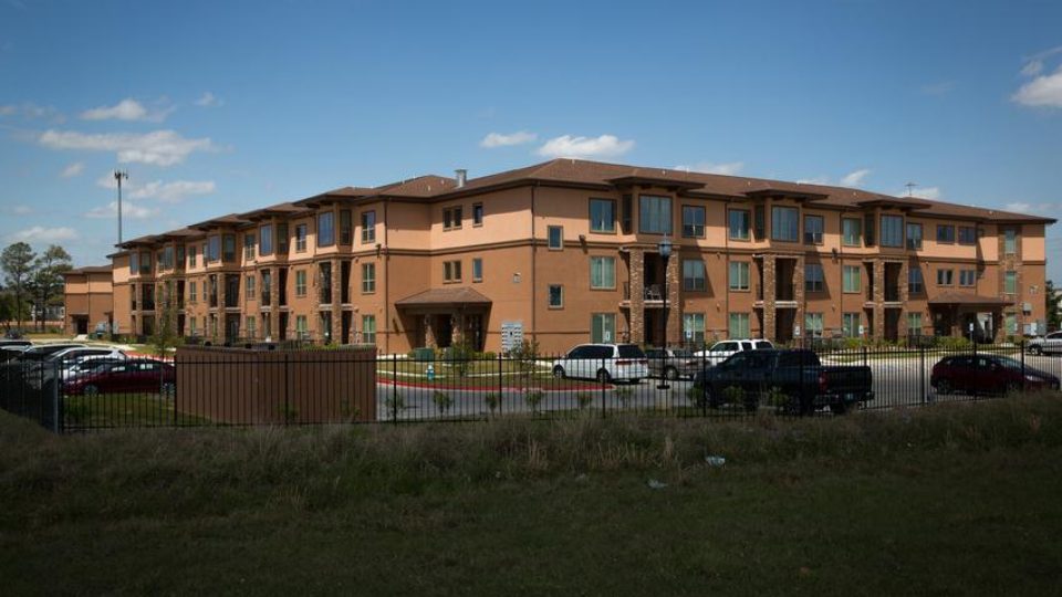 An apartment complex behind a metal fence