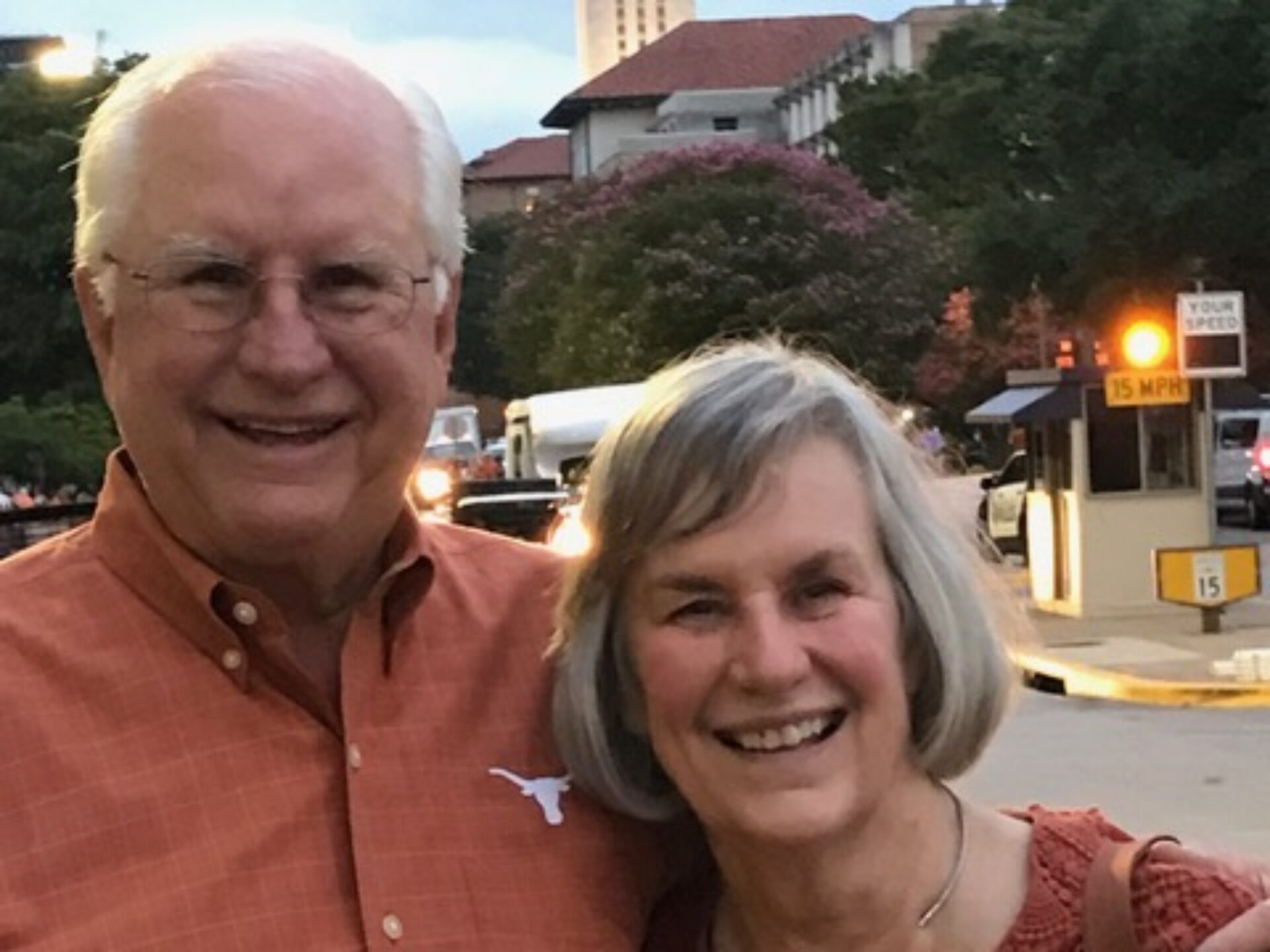 A couple poses on the UT Austin campus with the landmark UT Tower in the background.