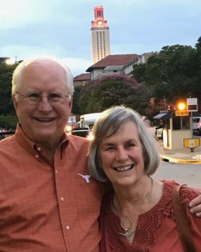 A couple poses on the UT Austin campus with the landmark UT Tower in the background.