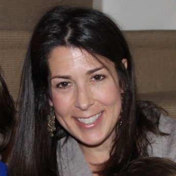 Woman with long, straight, brown hair smiles at the camera