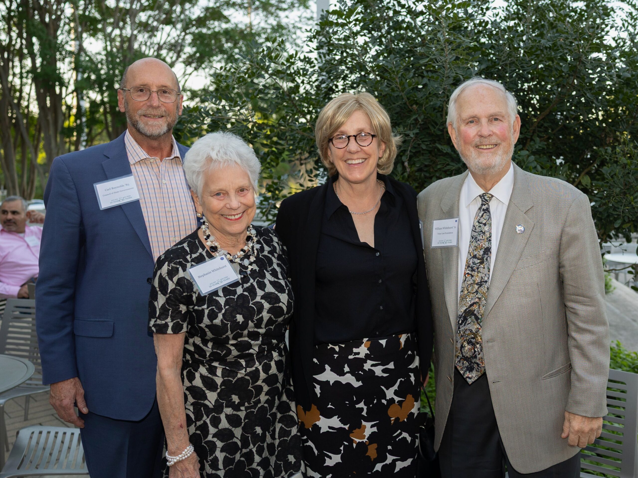 Four people smiling. Justice Center at 20 years.