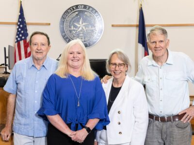 Pamela Sigman and three others stand in the Travis County court