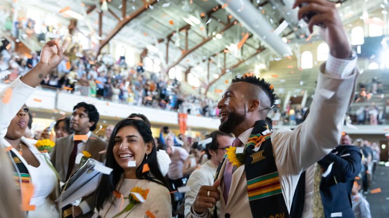 graduates celebrating with confetti falling around them