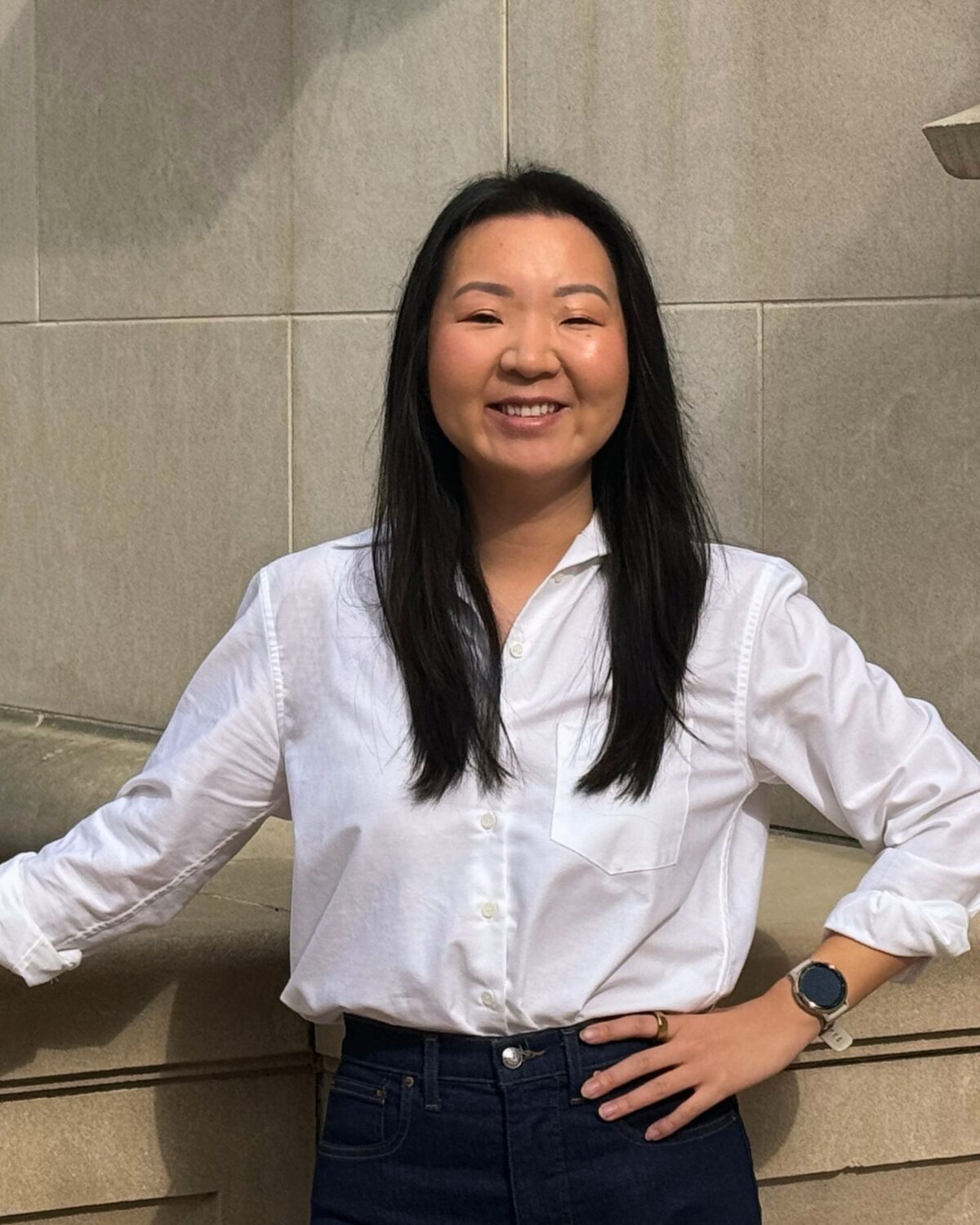 Lily Li on steps posed for headshot.