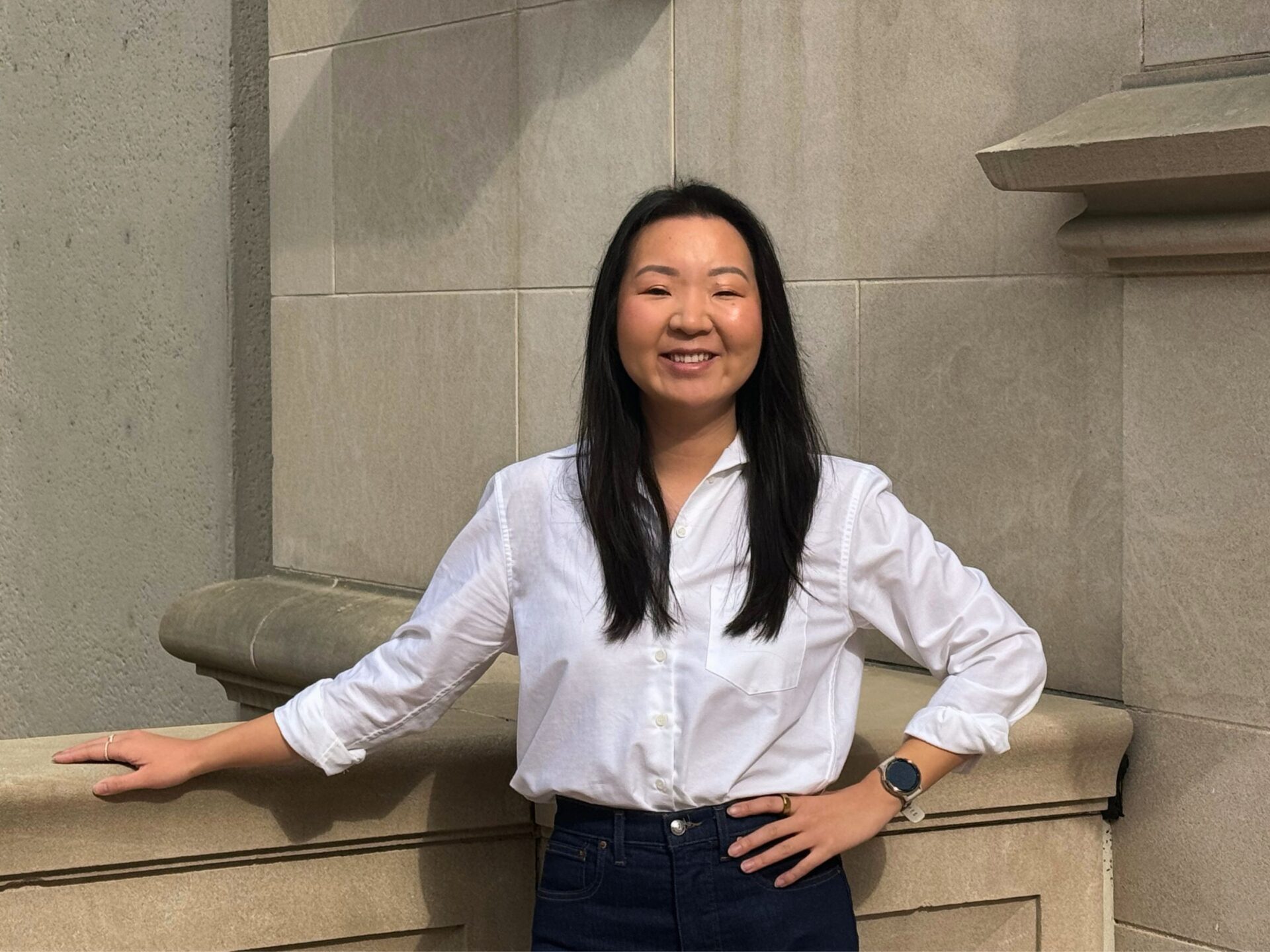 Lily Li on steps posed for headshot.