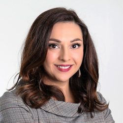 Portrait of Magda Herrera, smiling at the camera.