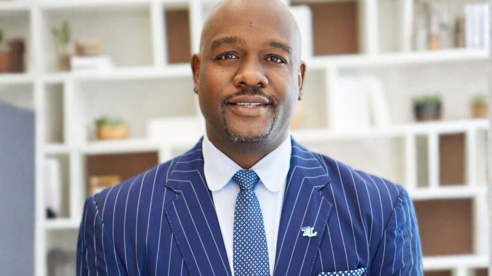 portrait of Marlen Whitley wearing a suite, in front of bookcase