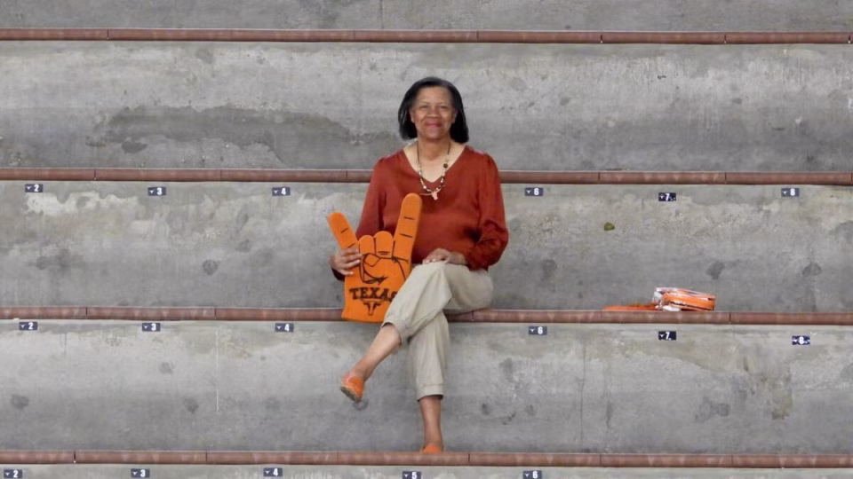 Professor Mechele Dickerson seated on bleachers