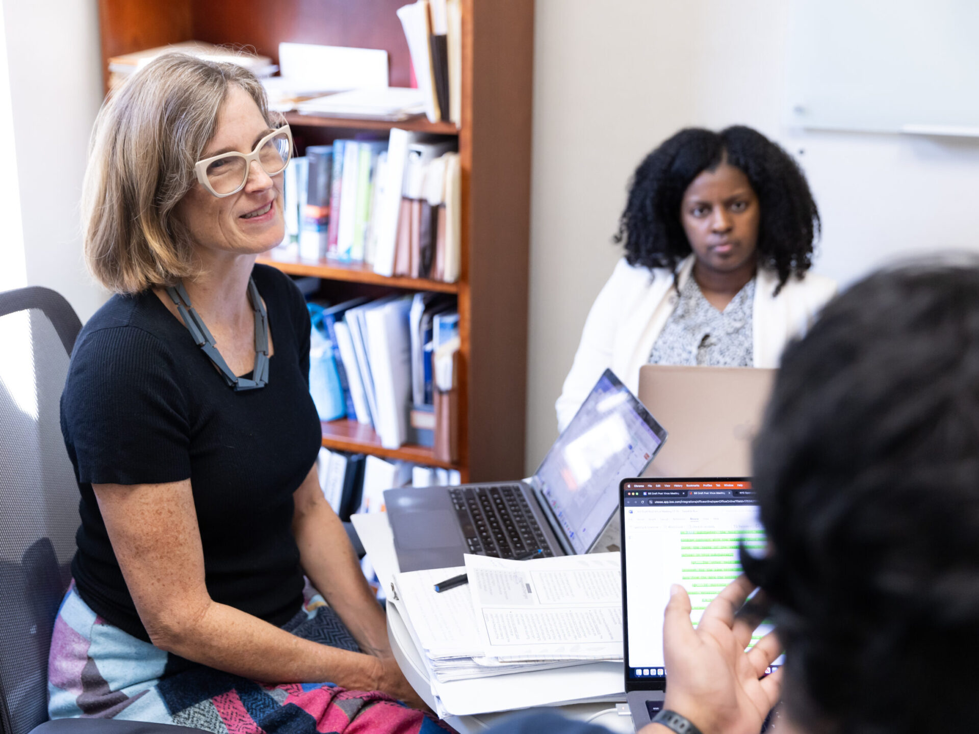 Heather Way teaching students in an office.