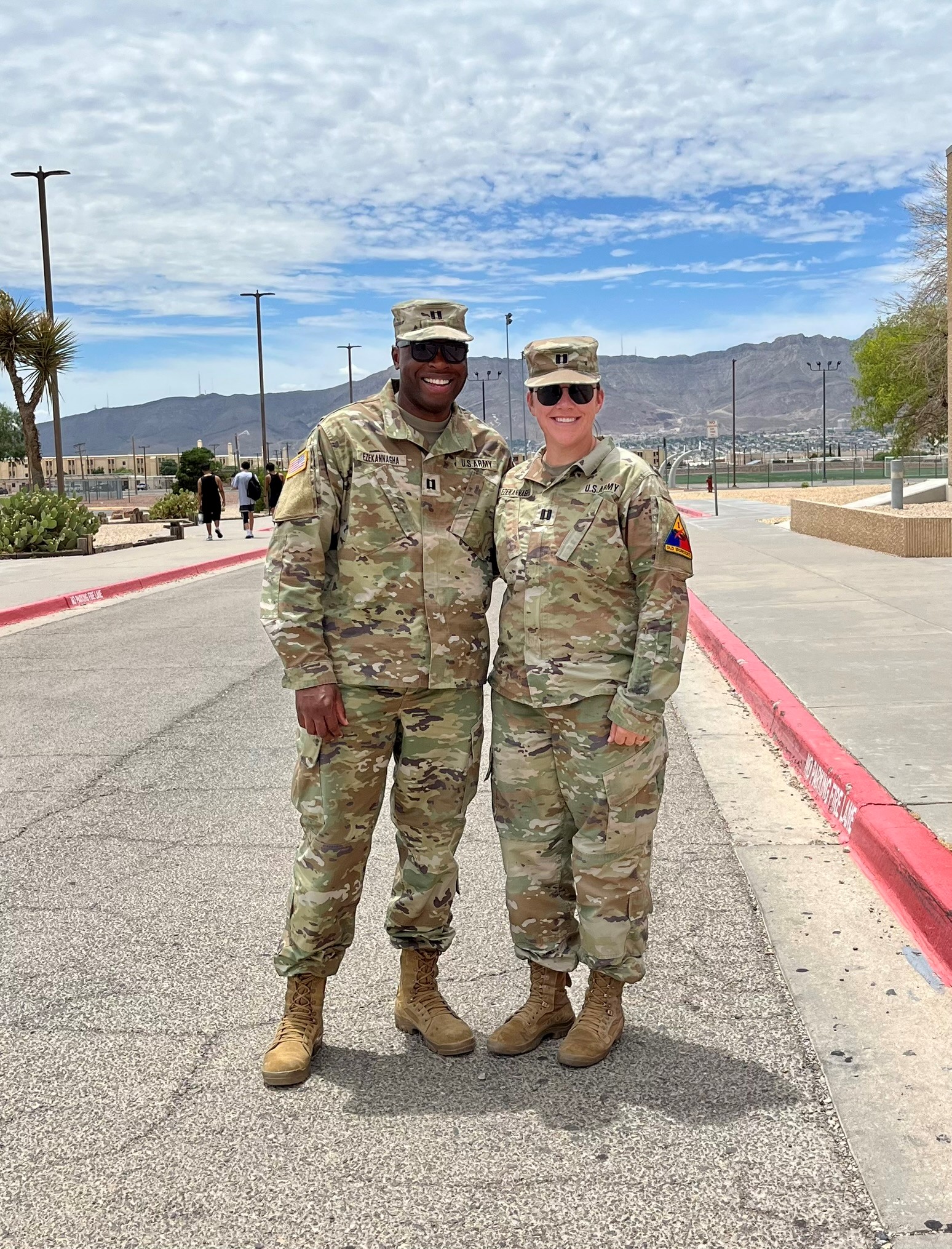 Meghan Ezekannagha ’26 with her husband, Chiazo, a Texas McCombs MBA '25, wearing military fatigues and standing side by side