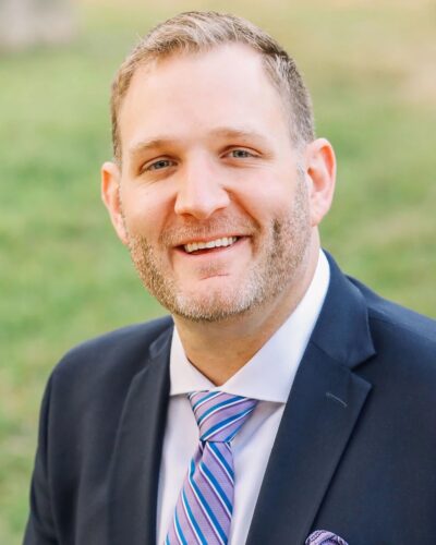 Portrait of Michael Ritter in suit with green grass in the background