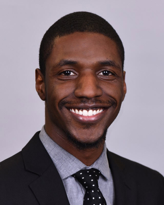 Portrait of Michael Vance, wearing a suit and black tie with white polka dots