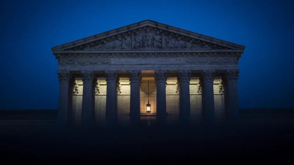 A photograph of the Supreme Court at night.