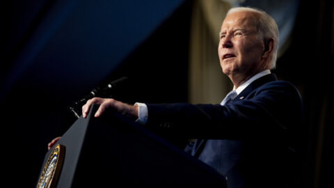 A photograph of President Biden standing at a podium.